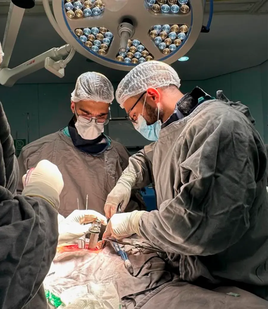 Dr. Caio Siqueira operando com a equipe no centro cirúrgico